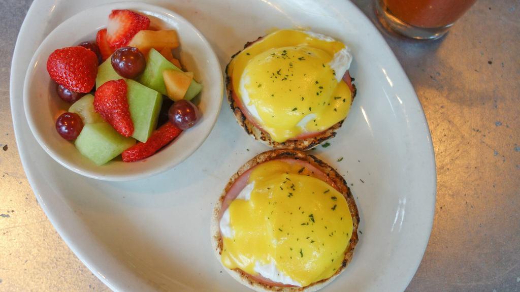 Traditional Eggs Benedict · 2 poached eggs with Canadian bacon atop English muffins with hollandaise sauce served with a choice of a breakfast side