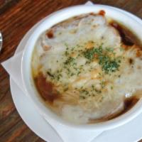 French Onion Soup · Traditional french onion soup topped with a large crouton jack and parmesan cheese.