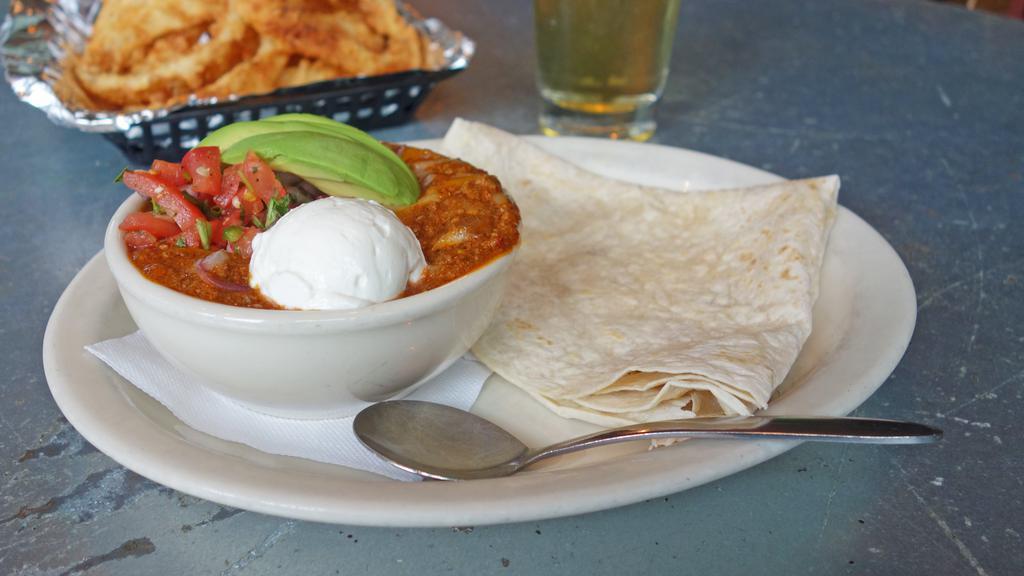 Ozona Chili Pie · An old roper's favorite. Homemade tostada chips topped with Ozona chili, jack and cheddar cheese, pico, sour cream and fresh sliced avocado a flour tortilla.