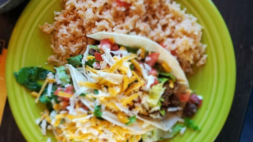 Taco Plate · Two tacos with your choice of meat served with either flour or corn tortillas topped with lettuce, tomatoes and cheese. Served with rice and beans.