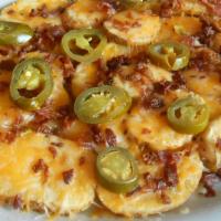 Irish Nachos · Thick cut potatoes topped with a melted cheese mix and bacon bits. Served with sour cream, j...