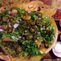 Everything Nachos · Homemade tortilla chips with fajita beef, fajita chicken and beans topped with lettuce, toma...
