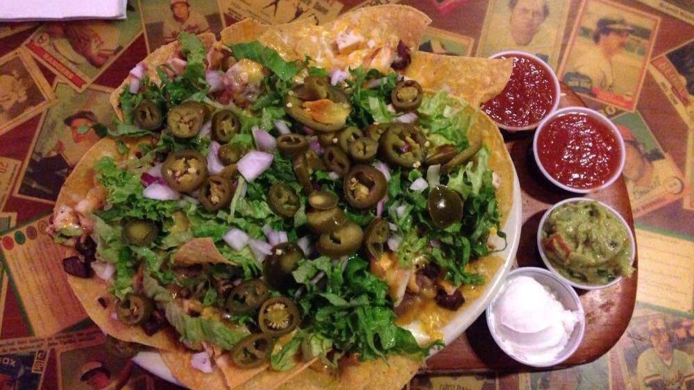 Everything Nachos · Homemade tortilla chips with fajita beef, fajita chicken and beans topped with lettuce, tomatoes, red onions, jalapeños and guacamole.