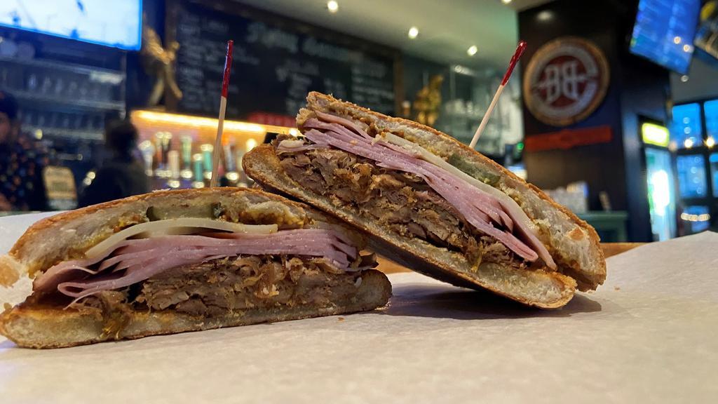 The Cuban · Slow cooked pork, vintage ham, stone-ground mustard, and pickles on Cuban bread.