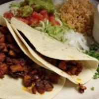 Tacos Al Pastor · Two delicious marinated pork and pineapple tacos served with fresh lime, onions, cilantro an...