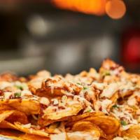 Loaded Chips · Our fried potato chips loaded with cheese, onions, tomatoes, jalapenos, chicken, and topped ...