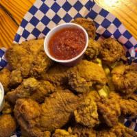 Cajun Seafood Platter · Three fillets of fish, five shrimp, five fried oysters and served with two hush puppies.