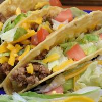 Crispy Tacos · Two ground beef or pulled chicken, lettuce, tomato and cheese, served with rice and beans.