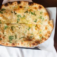 Naan Garlic · Flat bread baked in clay oven brushed with melted butter and garnished with fresh cilantro.