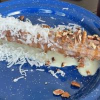 El Bandido Churro · Churro drizzled with Lechera, topped with pecans and shaved coconut.