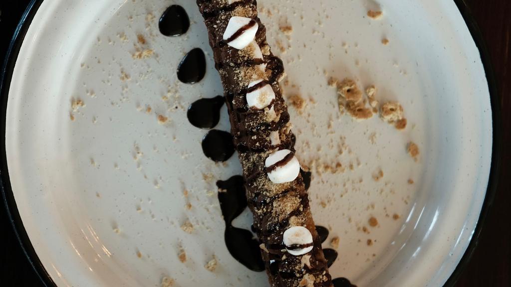 S' More Churro · Churro drizzled with marshmallow sauce, Nutella, Hershey's Chocolate topped with graham crackers and marshmallows.