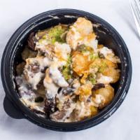 Nacho Tots · Marinated steak, smoked gouda and cheddar queso, guacamole and cilantro-lime crema over tate...