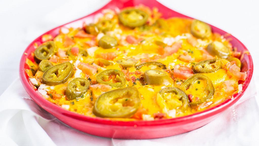Irish Nachos · Natural cut cottage fries with skins topped with melted cheddar cheese, bacon, chives, onions, tomatoes and jalapeños.