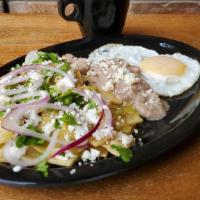 Chilaquiles · Fried tortilla chips topped with our delicious green tomatillo sauce, garnish with purple on...