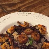 Moros Con Cristianos · Garlic sautéed jumbo shrimp atop a mix of white rice & black beans topped with fried plantai...