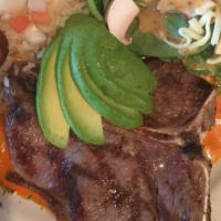T-Bone Patron · Grilled beef t-bone in a savory “Guajillo mole” sauce. Spinach salad, avocado & white rice w...