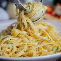 Fettucine Alfredo · Fettucine pasta in a homemade romano cheese sauce and fresh herbs.