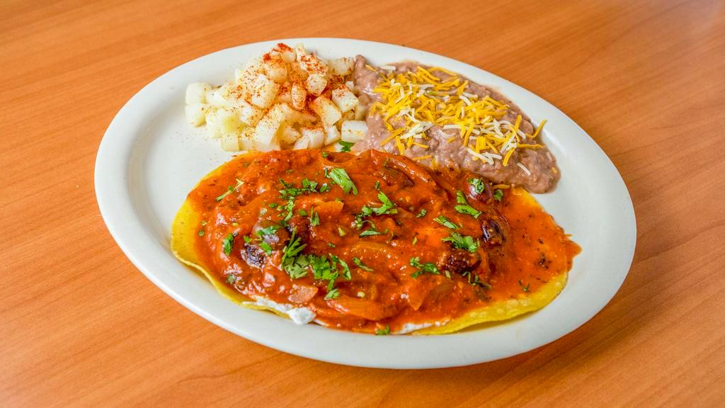 Huevos Rancheros · 2 over easy eggs on top of 2 corn tortillas topped with our Ranchero sauce and cilantro. Served with homestyle potatoes and refried beans.