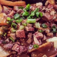 Poutine · Cut fries, cheese curds topped with poutine gravy & green onion as a garnish.
