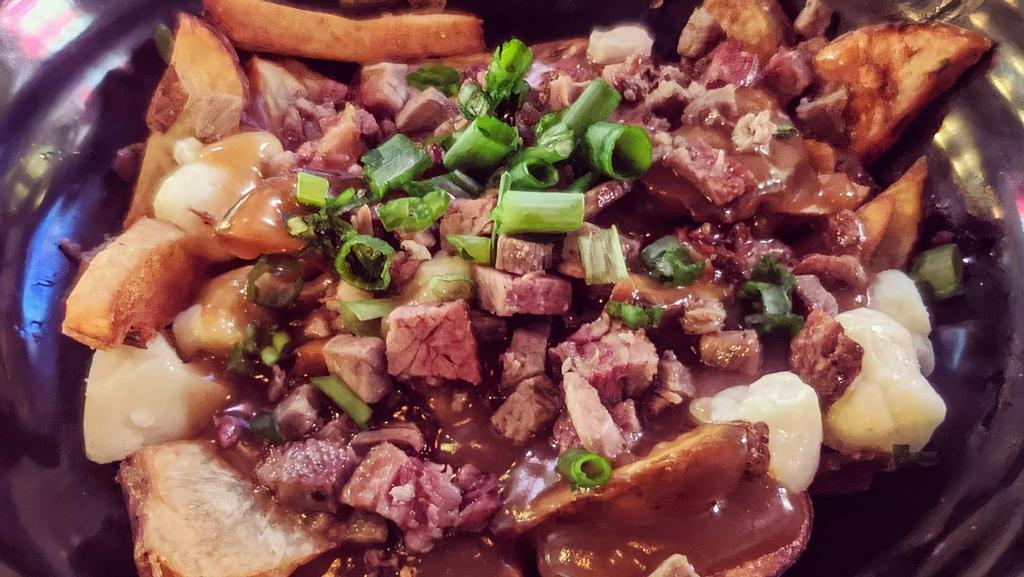 Poutine · Cut fries, cheese curds topped with poutine gravy & green onion as a garnish.