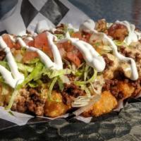 Taco Tots · Tots covered in queso, taco meat, shred cheese, lettuce, pico and sour cream sauce
