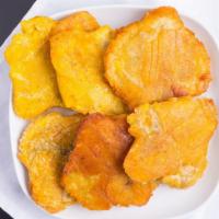 Tostones · thick slices of green plantain that are fried, flattened, and then fried again. Served with ...