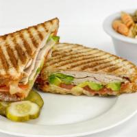 Turkey Avocado · Oven roasted turkey, sliced avocado, Swiss cheese, tomato and mayonnaise.  Served with a pic...