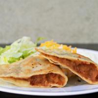 Refried Beans Pan Fried Taco · Pan fried taco with refried beans, lettuce, Cheddar cheese and Cotija cheese.