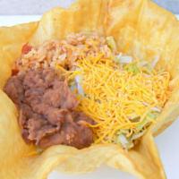 Taco Salad · Deep fried tortilla filled with rice, refried beans, lettuce, Cheddar cheese and choice of d...