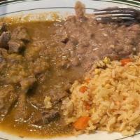 Carne Guisada · Beef stew, seared and braised in a tomato-serrano sauce. Served with Mexican rice, refried b...