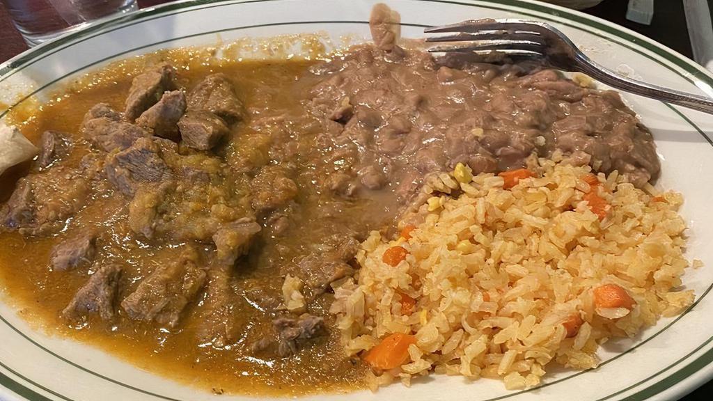 Carne Guisada · Beef stew, seared and braised in a tomato-serrano sauce. Served with Mexican rice, refried beans, and choice of corn or flour tortillas.
