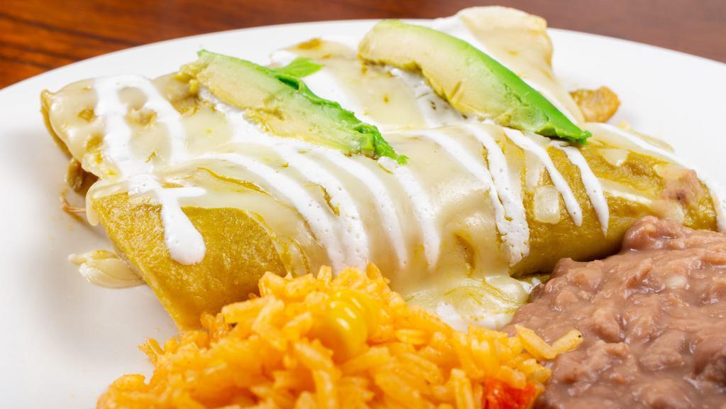 Suizas · Filled with shredded chicken. Topped with a creamy tomatillo sauce, melted Oaxaca cheese, and a slice of avocado. Served with Mexican rice and refried beans
