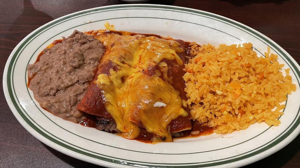 Tradicionales · Choice of ground beef or shredded chicken. Topped with Guajillo sauce and Oaxaca cheese, served with Mexican rice, and refried beans.