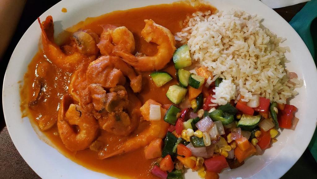 Camarones Chipotle · Large shrimp pan-seared with olive oil and fresh garlic, mushrooms, and braised in a roasted tomato-chipotle sauce. White rice and vegetables.