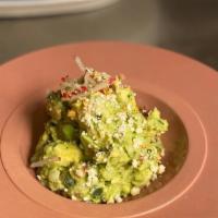 Guacamole De La Casa · House made all-day and topped with queso fresco, garlic chips and radish sticks.