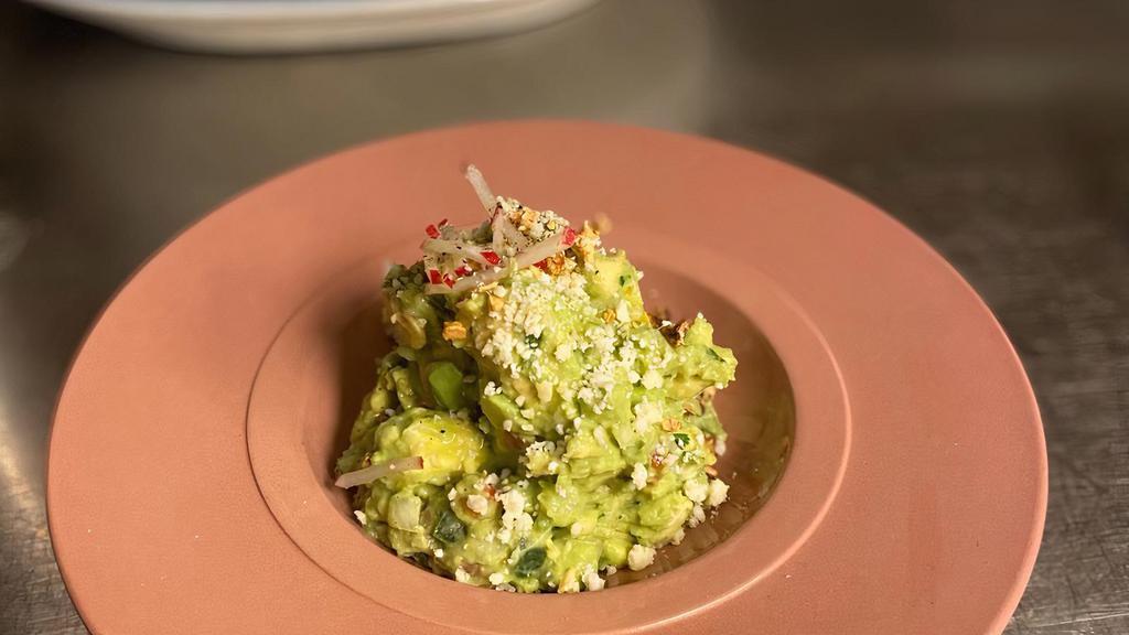 Guacamole De La Casa · House made all-day and topped with queso fresco, garlic chips and radish sticks.