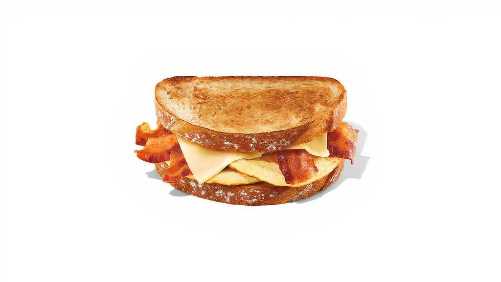 Sourdough Breakfast Sandwich · Two eggs, five half slices of bacon and white cheddar on two pieces of sourdough toast.