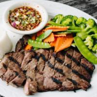 Tiger Cry · Grilled steak seasoned with herbs, with spicy tamarind sauce on the side. Served with steame...