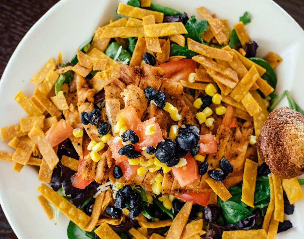 Southwest Chicken Salad · Black beans, corn, tomatoes, roasted chicken topped with crispy tortilla strips.