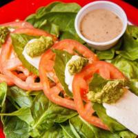 Caprese Salad · Baby spinach, basil, mozzarella, and tomatoes with pesto and your choice of dressing on the ...