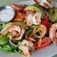 Ensalada De Camarones · Mixed salad with 6 large grilled shrimps with dressing on the side.