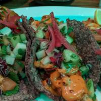 Fish Tacos · Three beer battered fish tacos on a blue corn tortilla topped with fresh fine cut vegetables...