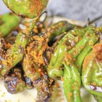 Charred Shishito Peppers · Soy sauce caramel, sesame, thai basil. This dish can be spicy. Bones can happen in dishes wi...