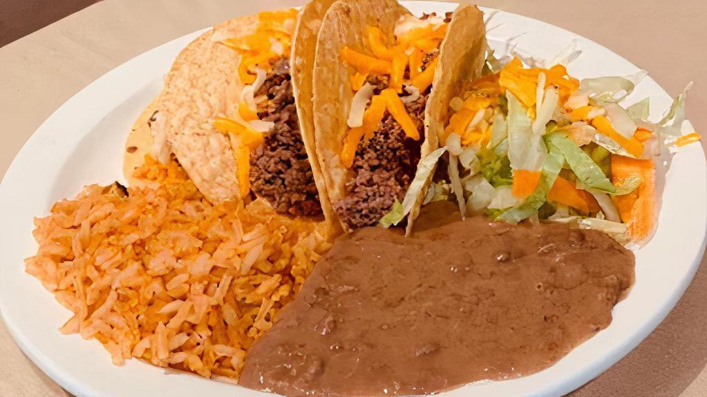 Tacos Al Carbon · Two beef tacos, rice, charro beans, guacamole, and pico de gallo.