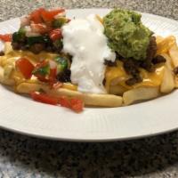 Fajita Fries · FAJITA ATOP OF BED OF GOLDEN FRENCH FRIES SMOTHERED WITH OUR  HOMEMADE CHILE CON QUESO AND Y...