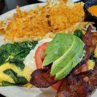Blt Omelette · 2 eggs omelette style with spinach and Swiss cheese. Topped with 2 sliced tomatoes, 2 strips...