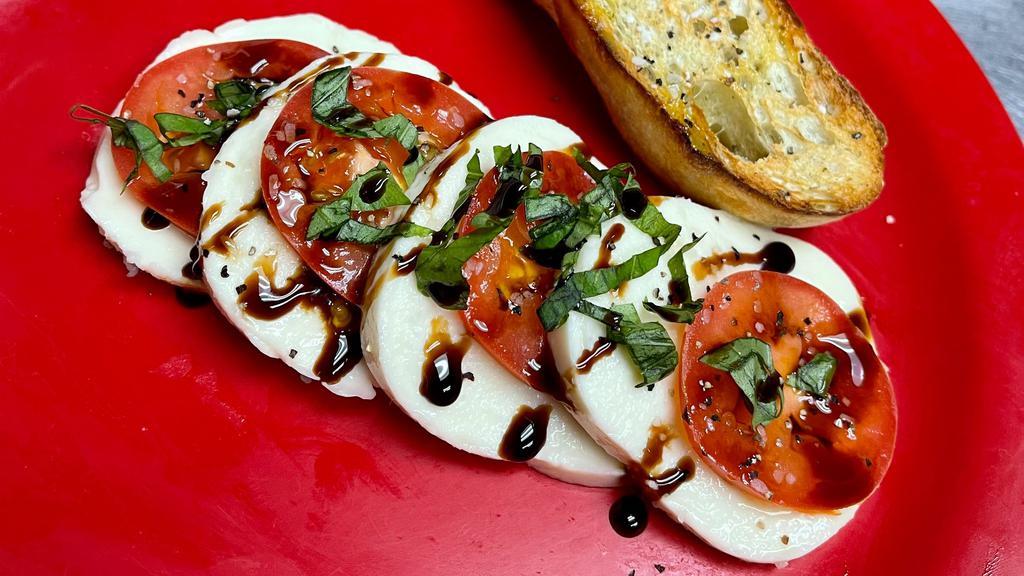 Caprice Salad · Slices of Roma tomato and mozzarella flavored with fresh basil leaves, olive oil, salt & pepper with a beautiful balsamic reduction & a focaccia wedge.