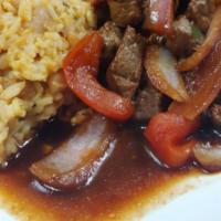 Tacu Tacu Con Lomo Saltado · Mixed rice and beans with beef seasoned with green onions, tomatoes, onions, and soy sauce.