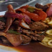 Tallarin A La Huancaina Con Lomo · Spaghetti served with huancaina sauce, topped with seasoned beef, green onions, tomatoes, on...
