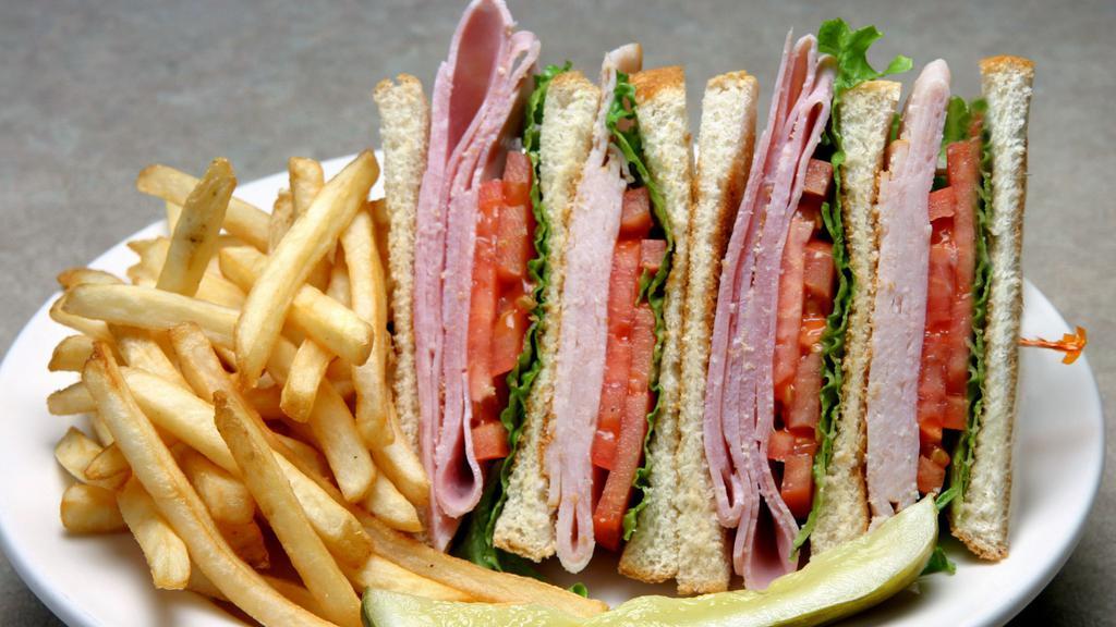Classic Club Sandwich · Choice of two freshly sliced Turkey, bacon, or freshly smoked ham on three pieces of toast, finished off with lettuce, tomato, and Mayonnaise. Served with choice of french fries, coleslaw, onion rings, cup of soup, or a side salad.